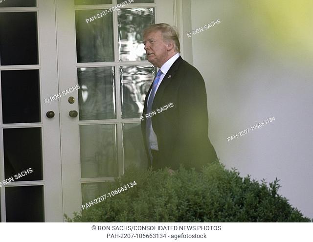United States President Donald J. Trump walks on the Colonnade to the Oval Office as he arrives back at the White House in Washington
