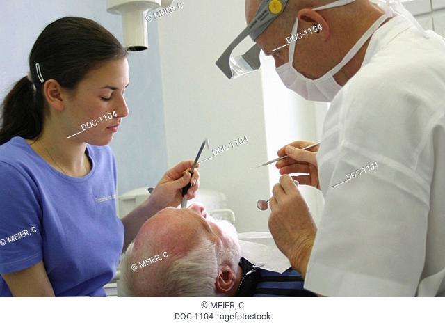 Dentist controls tartar with assistant at the patient