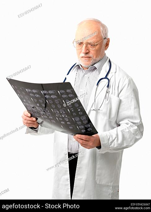 Portrait of serious senior doctor looking at X-ray image. Isolated on white background