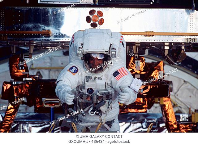 Astronaut Michael J. Massimino moves about in the cargo bay of the Space Shuttle Columbia while performing work on the Hubble Space Telescope (HST)