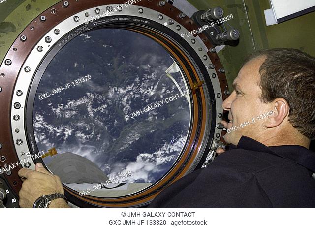 Astronaut Michael J. Bloomfield, STS-110 mission commander, looks through the Earth observation window in the Destiny laboratory on the International Space...