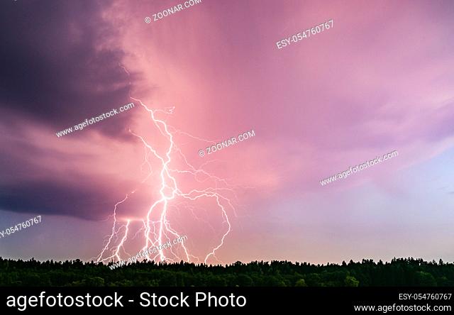 Lightning bolt at night over rural area. Agriculture fields