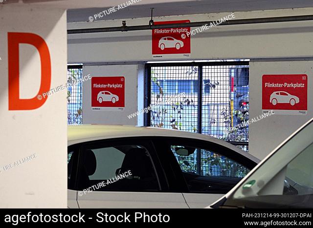 14 December 2023, Brandenburg, Potsdam: Signs with the red logo for ""Flinkster-Parkplatz"" are displayed in front of a parking bay in the parking garage at the...