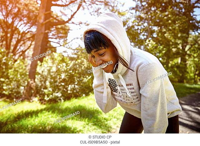 Young woman in rural setting, wearing hooded sweatshirt , smiling