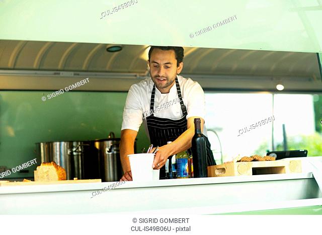 Small business owner preparing food in van food stall