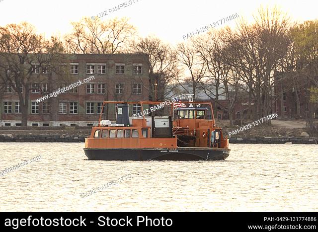 Bronx, New York, USA, April 16, 2020 - Ferry carrying Special Operation Medical Examiner refrigerated truck seen moving from City Island to Hart Island where...
