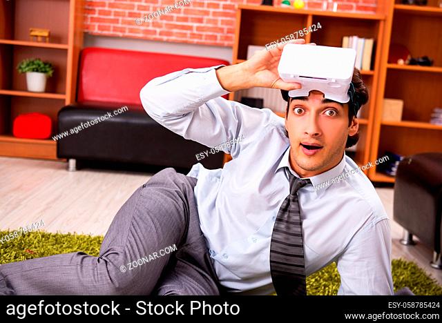 Young employee with virtual glasses during break in the office
