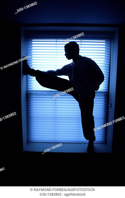 Man Stretching in Window