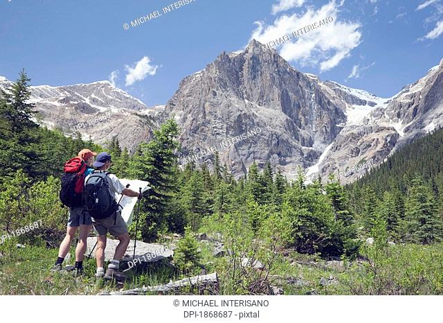 yoho national park, british columbia, canada, a couple hiking through the mountains and looking at a map