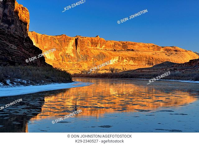 Sandstone walls reflected in the Colorado River at dawn during winter, Colordao Riverway Recreation Area Moab, Utah, USA