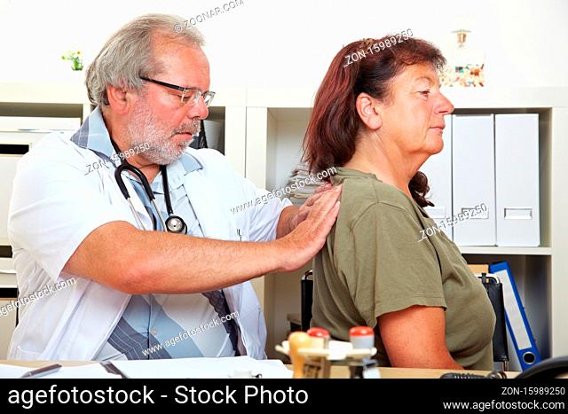 Arzt behandelt eine ältere Patientin mit Rückenschmerzen in seiner Praxis
