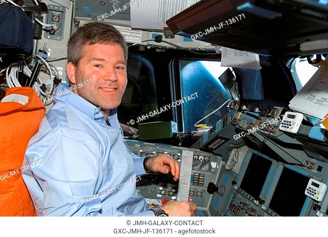 Astronaut Steve Frick, STS-122 commander, smiles for a photo while monitoring data at the commander's station on the flight deck of Space Shuttle Atlantis...