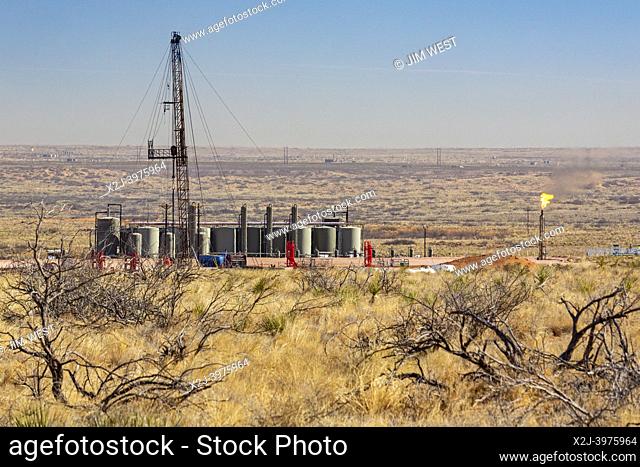 Loving, New Mexico - An oil drilling rig and oil storage tanks in the Permian Basin. The Permian Basin is a major oil and gas producing area in west Texas and...