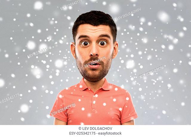 emotion, facial expression, winter, christmas and people concept - surprised man in polo shirt (funny cartoon style character with big head) over snow on gray...