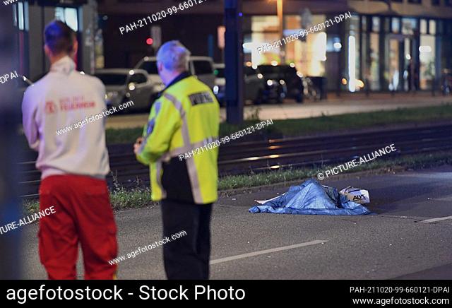 19 October 2021, Berlin: A pedestrian killed in an accident lies covered with cloths on Greifswalder Straße. According to previous findings