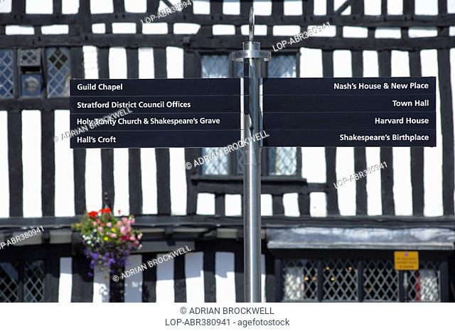 England, Warwickshire, Stratford-upon-Avon, A tourist information signpost in Stratford-upon-Avon in front of a medieval half-timbered house