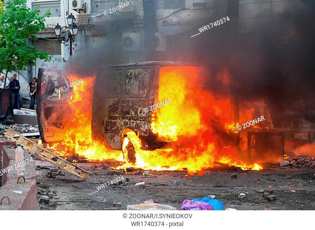 Burning car in the center of city during unrest