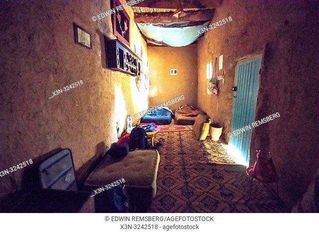 Interior of small bedroom with two mattresses on floor of traditional mud-brick built house in Tighmert Oasis, Morocco