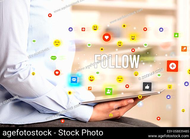 Close up of business person playing multimedia with social media icons and FOLLOW inscription
