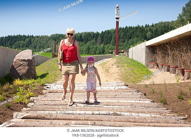 Mother and Kid Walking Together Holding Hands in Estonian Road Museum, Põlva County, Estonia