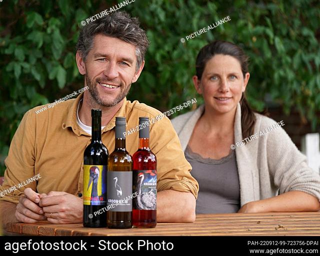 PRODUCTION - 09 September 2022, Schleswig-Holstein, Westensee: Organic winemaker Tobias Gerwig and his wife Josephine von Hedemann-Heespen sit at a table at the...
