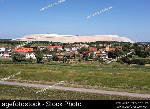 24 June 2023, Saxony-Anhalt, Zielitz: The tailings pile of the Zielitz potash plant rises behind the village of Loitsche