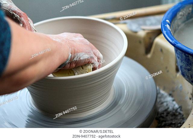 hands of a potter creating ceramic on the circle