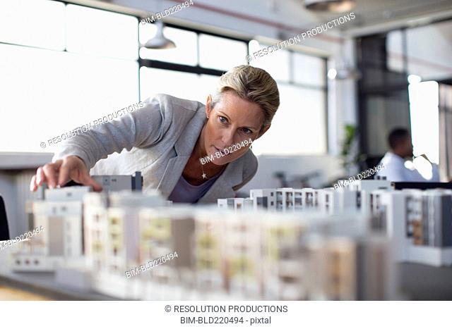 Caucasian architect examining architectural model in office