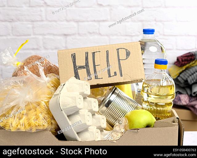 cardboard box with various products, fruits, pasta, sunflower oil in a plastic bottle and preservation. Donation concept