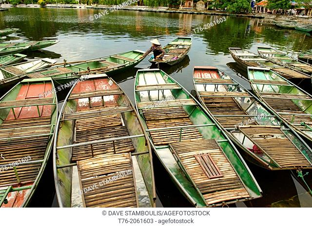 sightseeing boats docked on the Tam Coc River in Ninh Binh, Vietnam