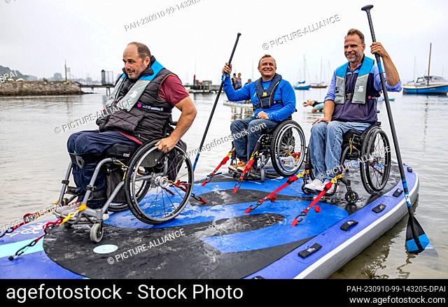 10 September 2023, Schleswig-Holstein, Eckernförde: Participants of the wheelchair SUP event ""Rolli on SUP"" on the Baltic Sea get ready for an outing on the...