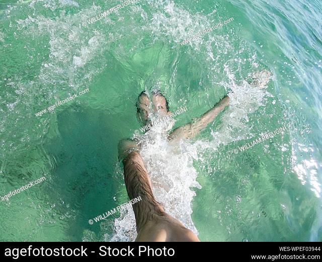 Mid adult man taking selfie while diving in water