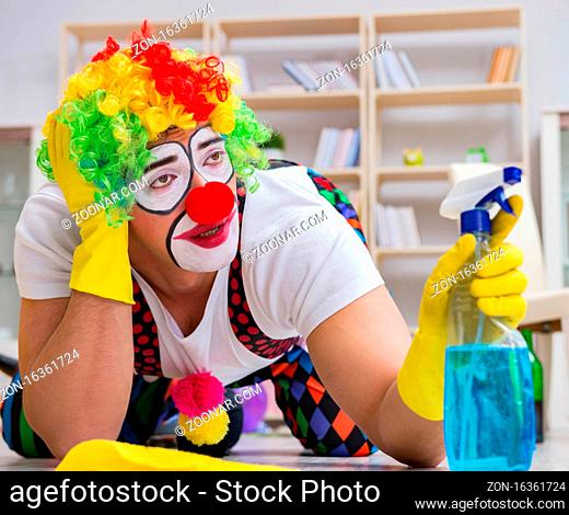 The funny clown doing cleaning at home