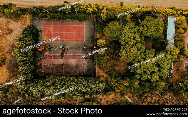 Aerial view of trees surrounding abandoned tennis courts