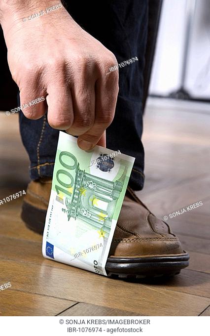 Man standing on a 100 Euro bill