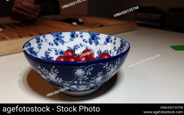 A bowl of marsipan chocolates and a hand
