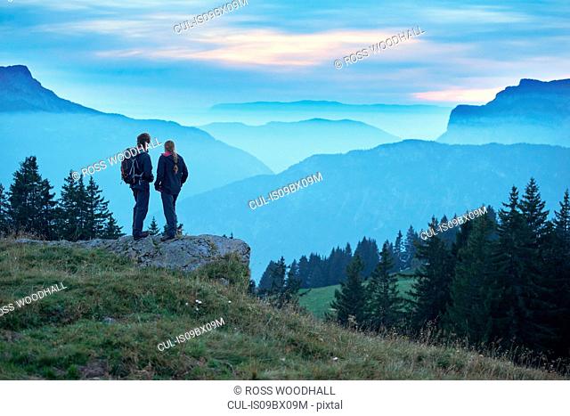 Hikers enjoying view of misty mountains, Manigod, Rhone-Alpes, France