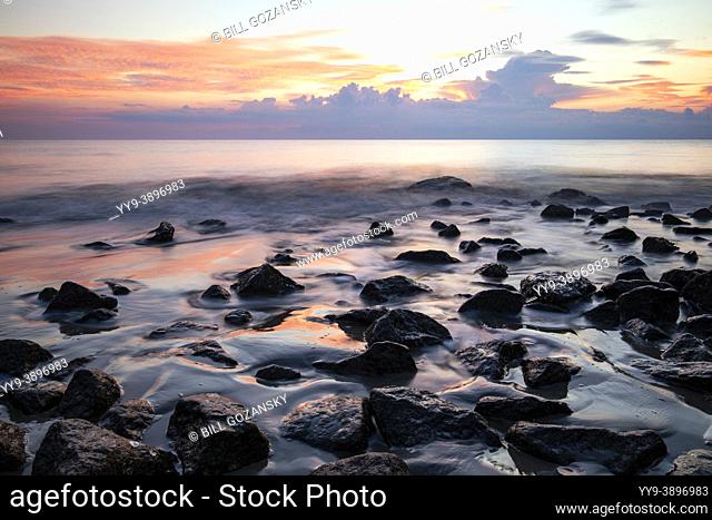 Ethereal sunrise on rocky coastline of Driftwood Beach - Jekyll Island, Georgia, USA