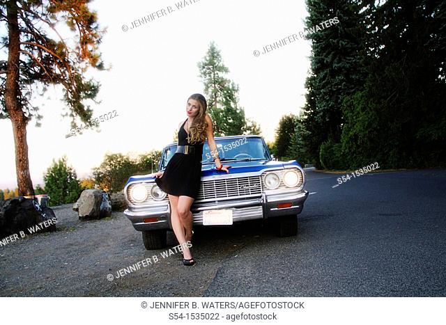 A young woman with a 1964 Chevrolet Impala in Spokane, Washington, USA