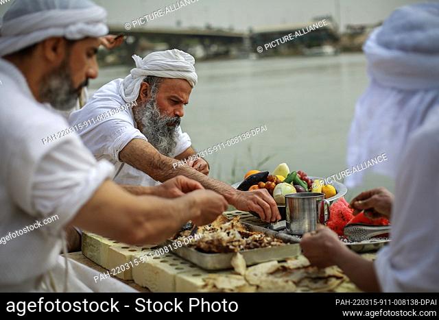 15 March 2022, Iraq, Baghdad: Followers of the Sabean-Mandaean religious sect eat on the banks of Tigris River during Eid Al-Khalqeh (the feast of creation)