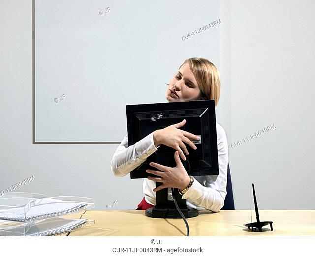 Woman hugging computer screen
