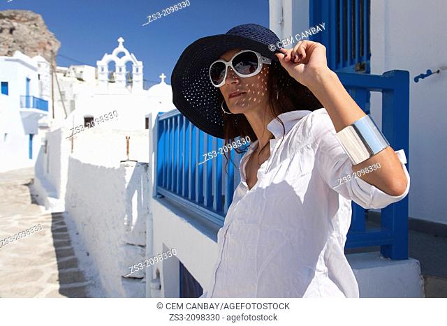 Woman posing in Chora near a church, Amorgos, Cyclades Islands, Greek Islands, Greece, Europe
