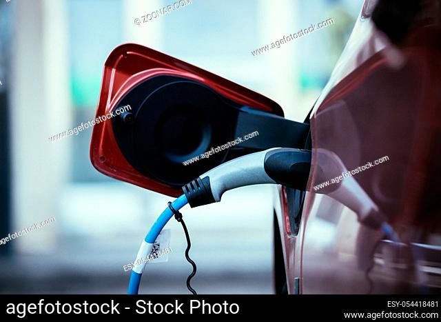 Electric car recharging with charge cable and plug leading to charge point