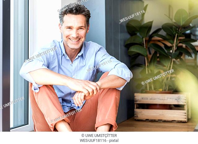 Mature man relaxing at home, smiling