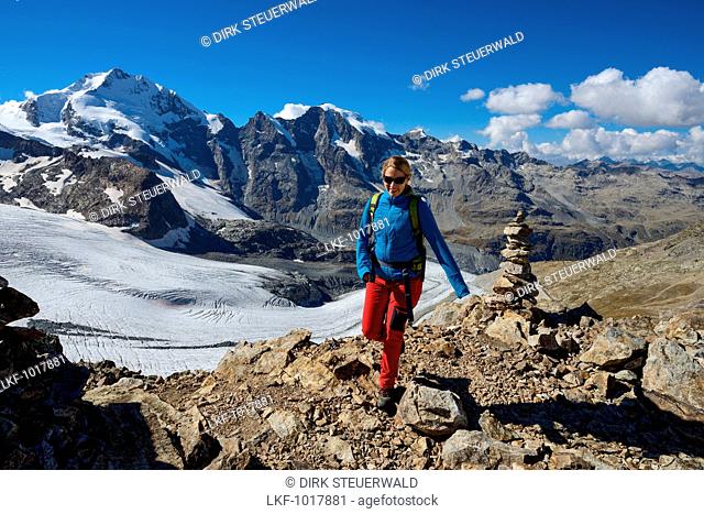 Woman at the summit of Piz Trovat (3146 m) with view to the Bernina-Alps with Bellavista (3922 m), Piz Bernina (4049 m), Piz Morteratsch (3751 m) as well as...
