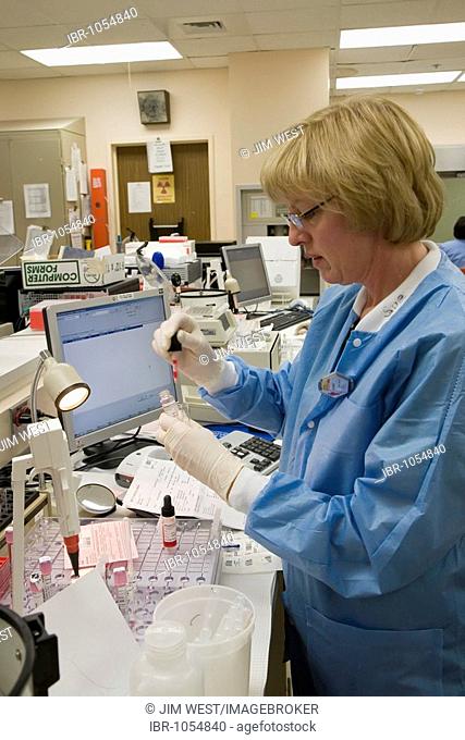 Medical technologist Sue Maynard runs blood tests ordered by doctors at the Detroit Medical Center, Detroit, Michigan, USA