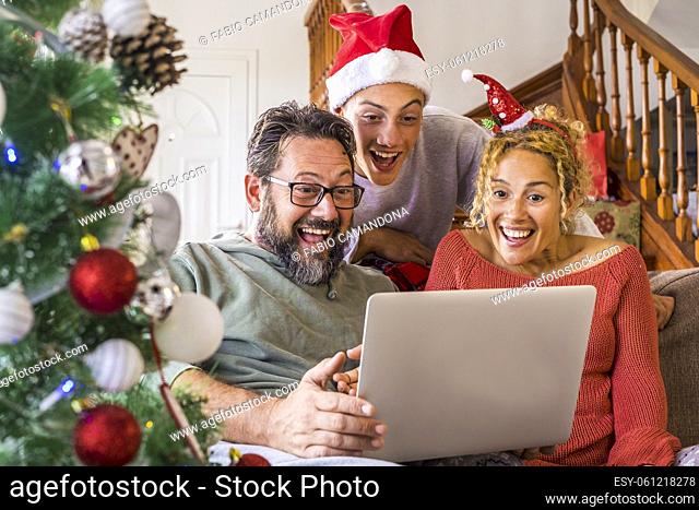 Happy family using laptop for video chatting on the eve of Christmas. Family celebrating Christmas on video conference. Excited family video chatting with near...