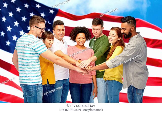 diversity, teamwork, race, ethnicity and people concept - international group of happy smiling men and women holding hands together over american flag...