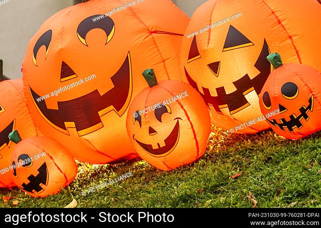 30 October 2023, Hesse, Wiesbaden: Inflatable Halloween pumpkins are set up for decorative purposes in a front yard. In the ""Housing Areas"" Aukamm and...