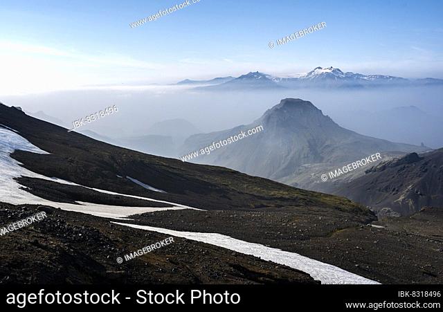 View of mountain peaks between fog, peak Útigónguhöfdi, behind peak Ymir and Ásgrindur with glacier Tindfjallajökull, hiking trail Fimmvörðuháls, Heljarkambur